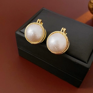 Gros plan détaillé de boucles d'oreilles perles rondes rétro avec bordure dorée sur boîte