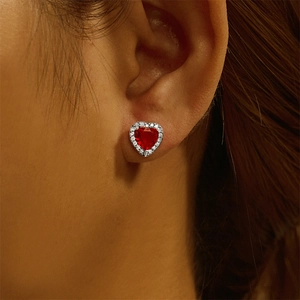 Close-up of red heart stud earrings with s925 sterling silver and zircon setting on ear