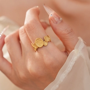 Detail of matte gold oval pleated open ring with handmade hammered texture on model