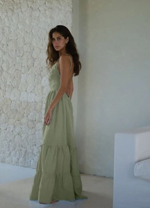 Détail d'une robe longue dos nu vert sauge avec de fines bretelles et jupe à volants