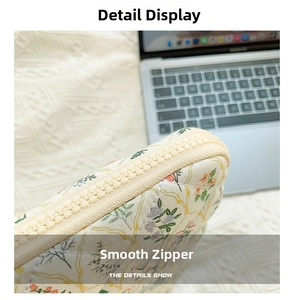 Detailed close-up of the smooth zipper and floral fabric on this laptop sleeve