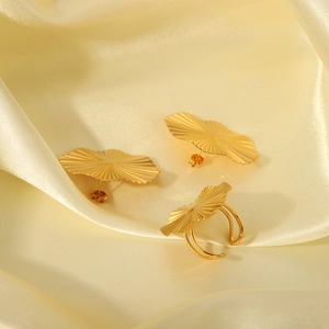 Exquisite gold jewelry set with fan-shaped ring and earrings on soft silk fabric