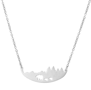 Macro d'un pendentif argenté ajouré avec une famille d'ours dans une forêt de pins