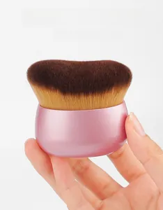 Close-up of dense flat foundation brush with pink metallic handle for makeup