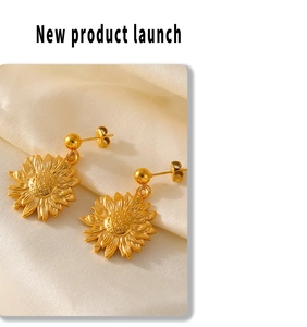 Close-up of golden sunflower earrings featuring textured petals on silk fabric
