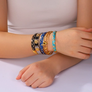 Set of gold-plated stainless steel bangles with colorful enamel star and moon patterns
