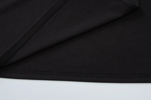 Detailed macro view of black fabric texture and premium stitching on the dress hemline