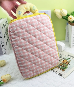 Close-up of yellow embroidered Melody handle on pink plaid quilted laptop sleeve bag