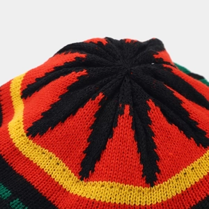 Macro detail of Rasta beanie crown with knit leaf pattern in red, yellow, and green