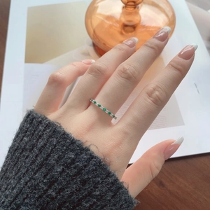 Close-up of S925 silver ring with alternating green and white stones on a finger