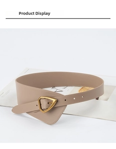 Close-up of wide camel leather corset belt featuring a golden triangle buckle and metal eyelets