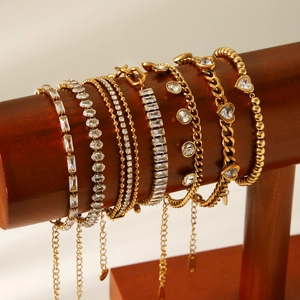 Detailed display of gold stainless steel zircon bracelets on a dark wooden jewelry stand