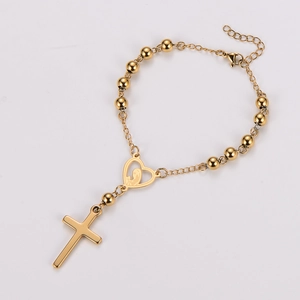 Detail of gold rosary bracelet featuring heart-shaped Virgin Mary charm and cross pendant