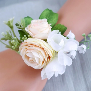 Elegant ivory and pink rose wrist corsage with green leaves for weddings and events
