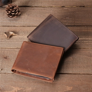 Vintage brown crazy horse leather wallets for men on a rustic wooden surface
