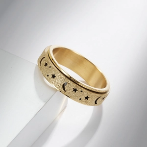 Gold rotating stainless steel ring with star and moon patterns on matte sandblasted surface