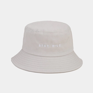 Détail de la broderie Stay Wild et coutures renforcées sur un chapeau bob en toile beige