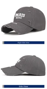 Detail of distressed dark grey baseball cap with white PARIS embroidery and worn texture