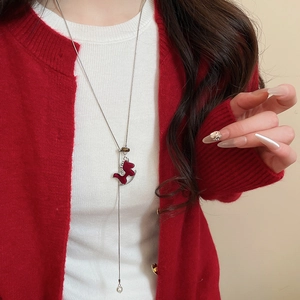 Détail du collier pendentif cheval floqué bordeaux avec franges en perles
