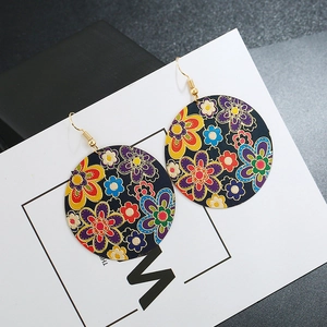 Detailed close-up of colorful floral patterned round earrings with gold-plated hooks