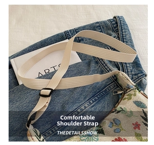 Detail of adjustable beige fabric shoulder strap and floral embroidery pattern on the crossbody bag