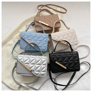 Detailed view of women's quilted crossbody bags in beige, blue, white, silver and black