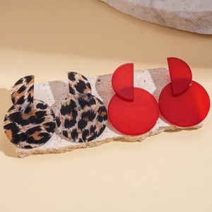 Acrylic leopard print and red geometric hoop earrings displayed on a stone slab