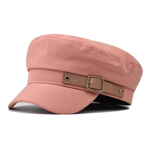 Detail of pink cotton newsboy cap with brown leather strap and matte metal buckle