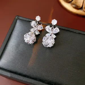 Boucles d'oreilles papillon élégantes avec zircons brillants sur boîte en cuir noir