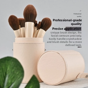 Detail showing professional makeup brush set with off-white wooden handles and leather case