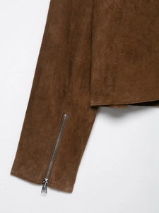 Détails de la veste en daim marron montrant le poignet et la fermeture éclair en métal