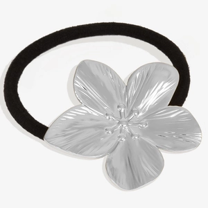 Detail view of a silver 304 stainless steel flower charm on a black elastic hair tie