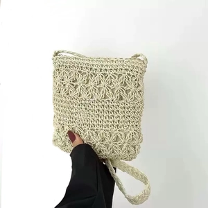 Handmade crochet crossbody bag in beige featuring hollow flower patterns and fringe