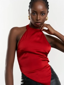 Détail du haut dos nu en satin rouge avec ourlet irrégulier et texture soyeuse