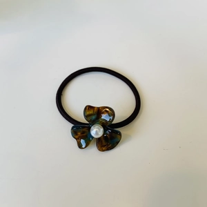Elegant floral hair tie featuring a dark tortoiseshell resin petal and white pearl detail