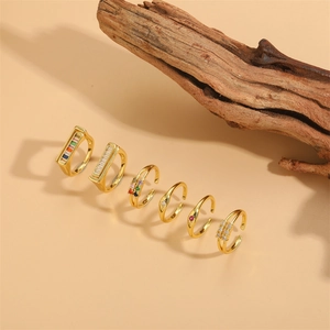 Set of gold double-layer open rings with colorful geometric zircon stones on wood