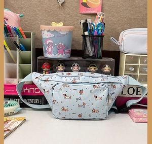 Detail of light blue crossbody bag featuring cute cartoon dachshund prints and dual zippers