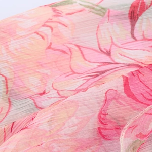 Detailed macro view of pleated fabric with delicate pink flower print on lightweight chiffon