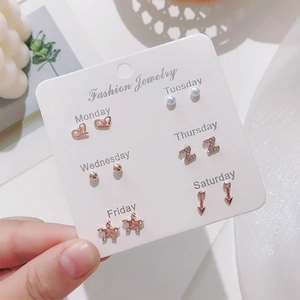 Detailed set of 6 pairs of rose gold stud earrings labeled by days of the week