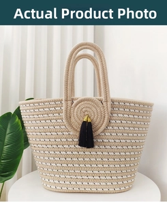 Detailed macro view of woven straw tote bag featuring striped texture and black tassel charms