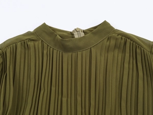 Close-up of elegant pleated green chiffon neckline featuring back zipper and fine texture