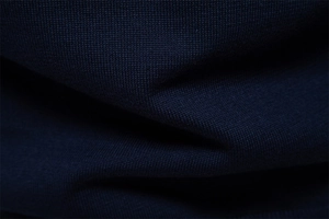 Close-up of high-quality dark blue knitted fabric showing fine textile texture and weave