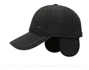 Detail view of a dark grey men's winter baseball cap with textured fabric and fold-out earflaps