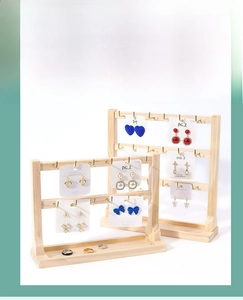 Solid wood jewelry display stand with golden metal hooks and a recessed base tray
