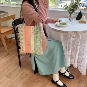 Sac fourre-tout en toile à patchwork floral présenté dans un café cosy avec détails