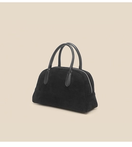 Detail of premium black suede bowling bag with leather handles and textured finish