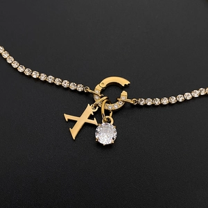 Macro view of 14K gold plated necklace with sparkling CZ pendant and letter X charm