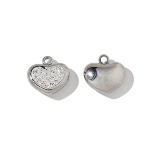 Detailed macro view of heart-shaped pendants with zircon inlay and polished steel back