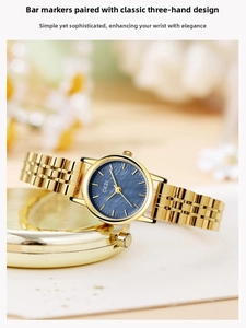 Detalle de reloj de lujo para mujer con esfera azul y correa de acero dorado