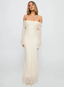 Detailed close-up of floral lace texture on a white off-shoulder maxi dress with bell sleeves